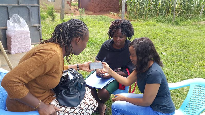Dr Diana training two field workers on utilising the mobile application